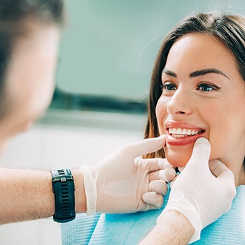 A dentist assessing a woman for cosmetic dentistry