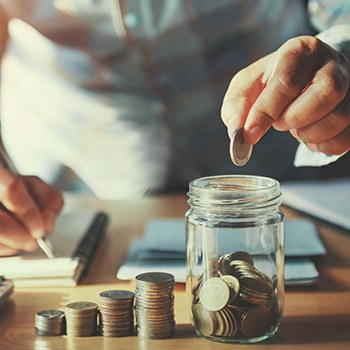 Someone putting coins into a jar